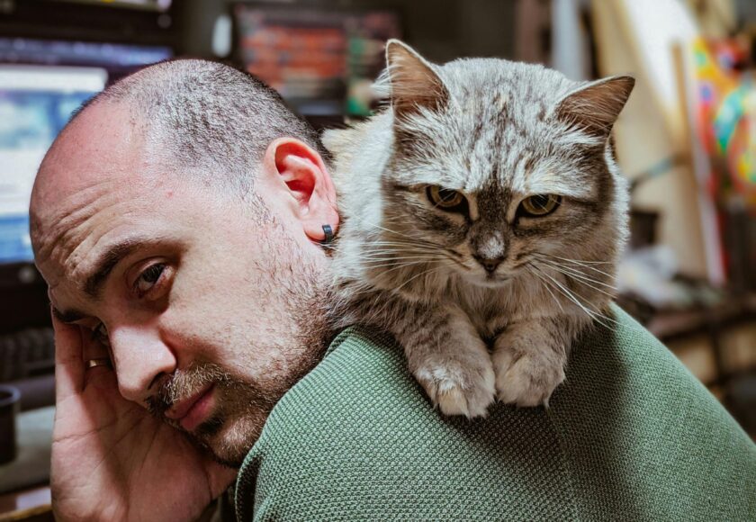 Cat Lying on a Man’s Back